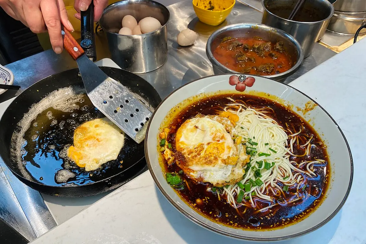 Chongqing xiaomian noodles topped with fried eggs and chopped spring onions